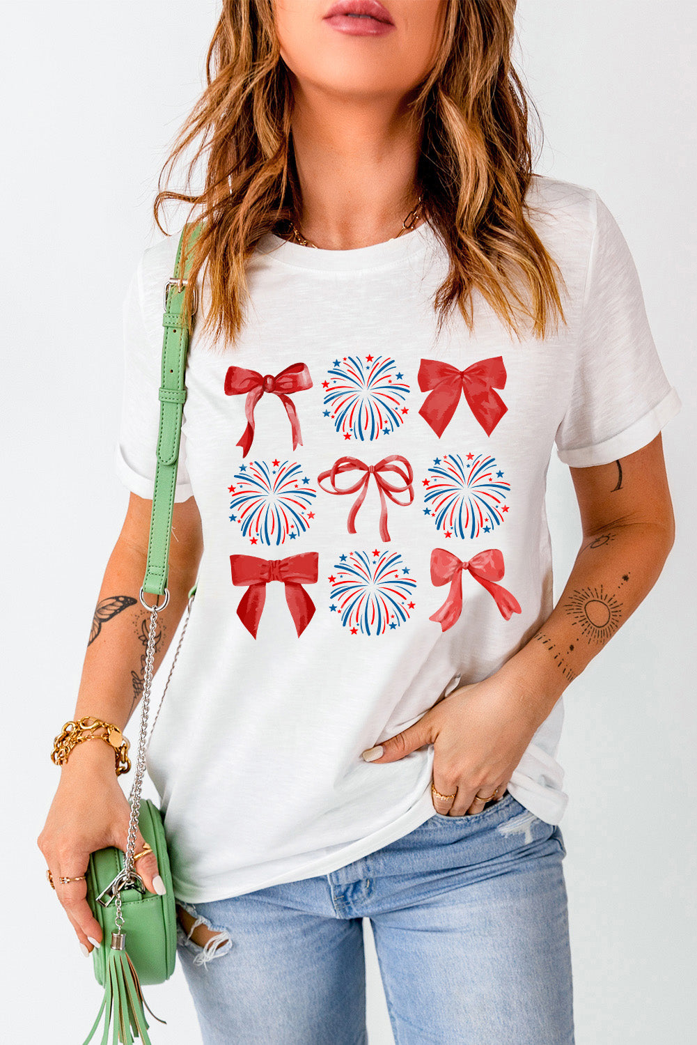 White t-shirt with red bows and red and blue fireworks graphic print.