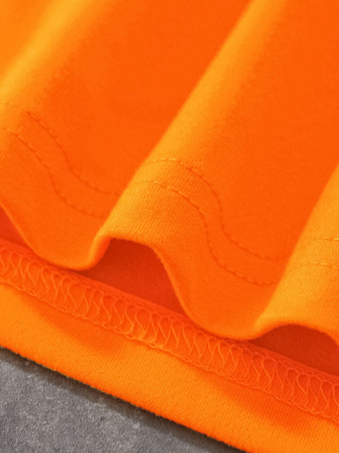 Orange cotton crew neck t-shirt detail showing stitching