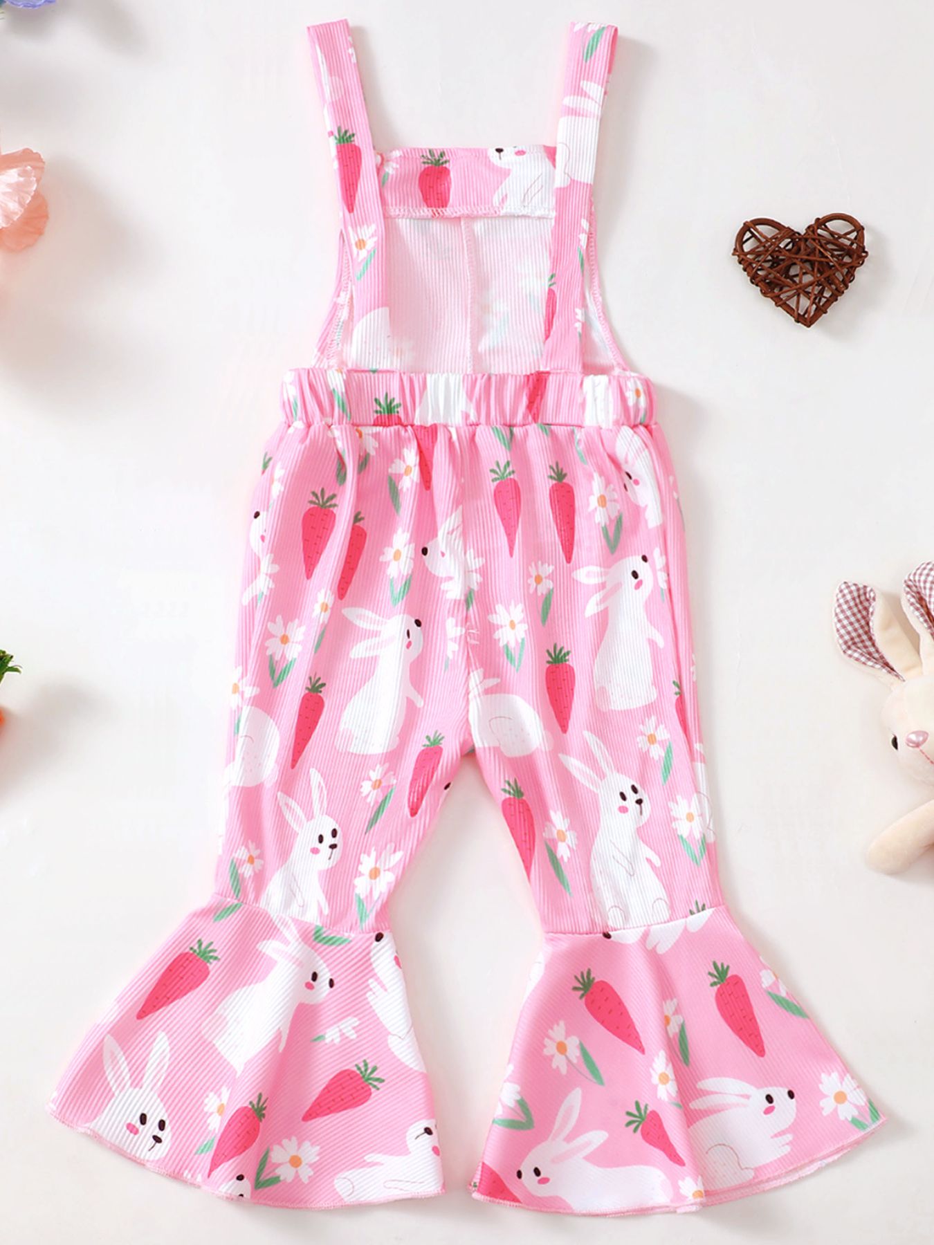 Pink baby overalls with adjustable straps, flare legs, and a playful bunny and carrot print.