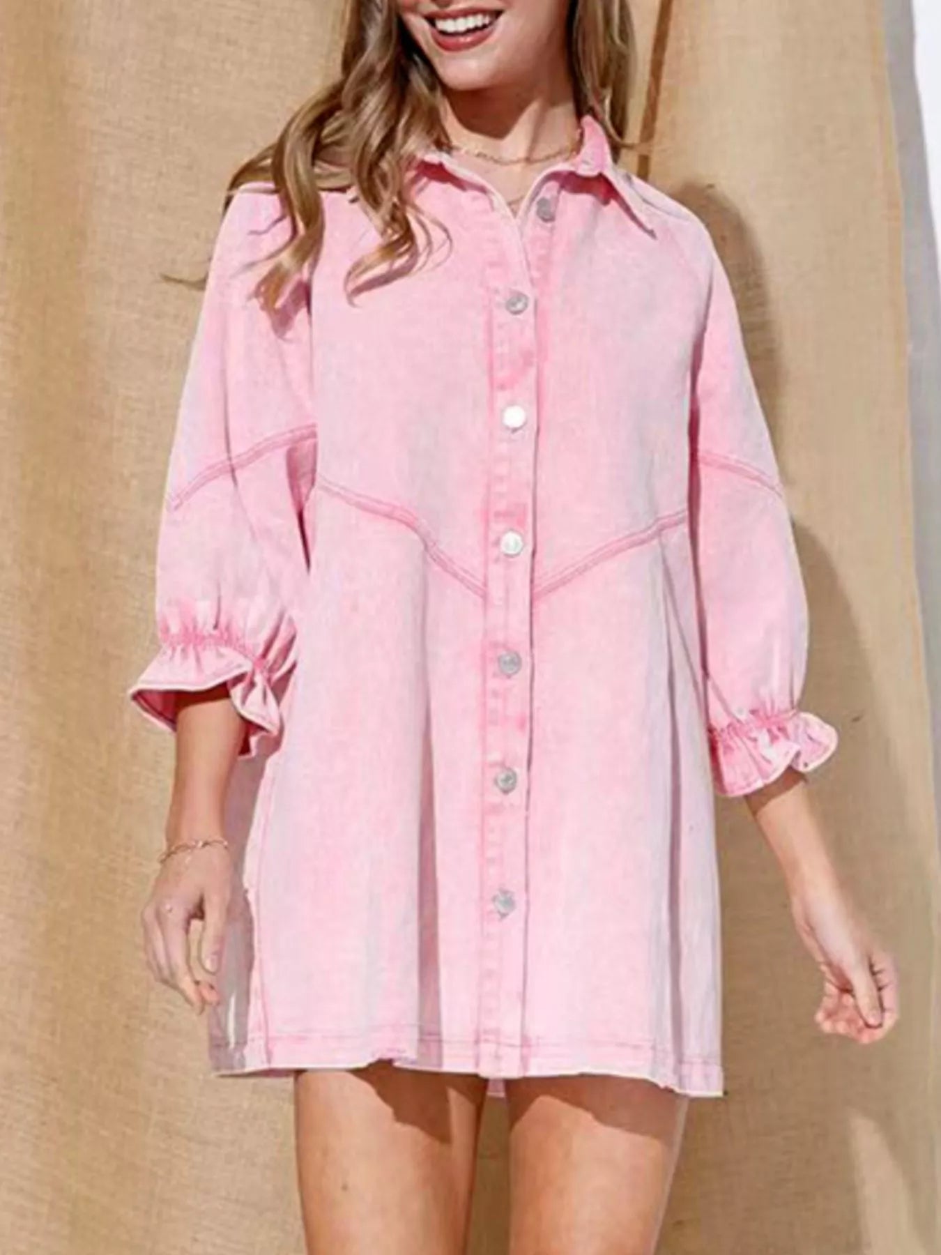 Blush pink denim button-down dress with ruffled cuffs and contrast stitching.