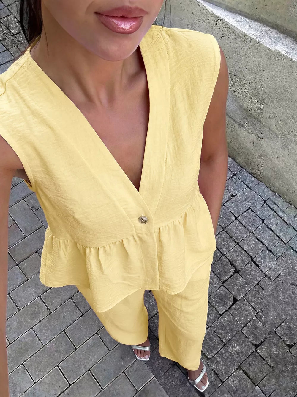 Yellow peplum hem two-piece set with button detail and V-neck top.