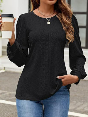 Black perforated puff sleeve blouse with textured fabric and crew neck.