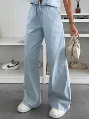 Light blue denim wide-leg pants with drawstring waist and relaxed fit.