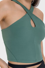 Teal keyhole halter crop top with crisscross straps and a cutout detail.