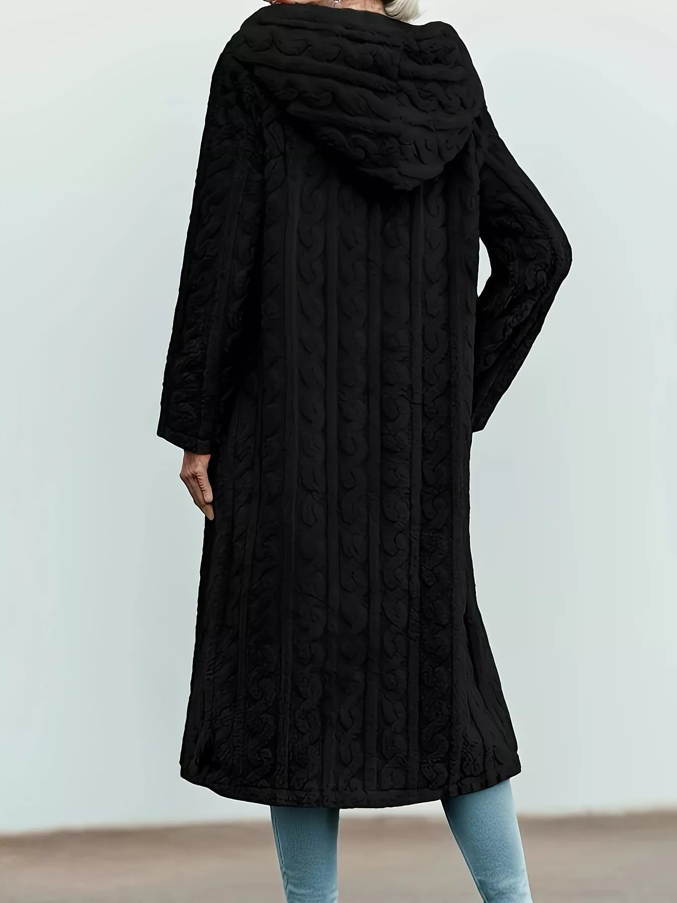 Black hooded longline button up outerwear with cable knit texture and flowing hem.