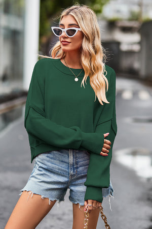 Dark green ribbed knit batwing sweater with crew neck and cuffed sleeves.