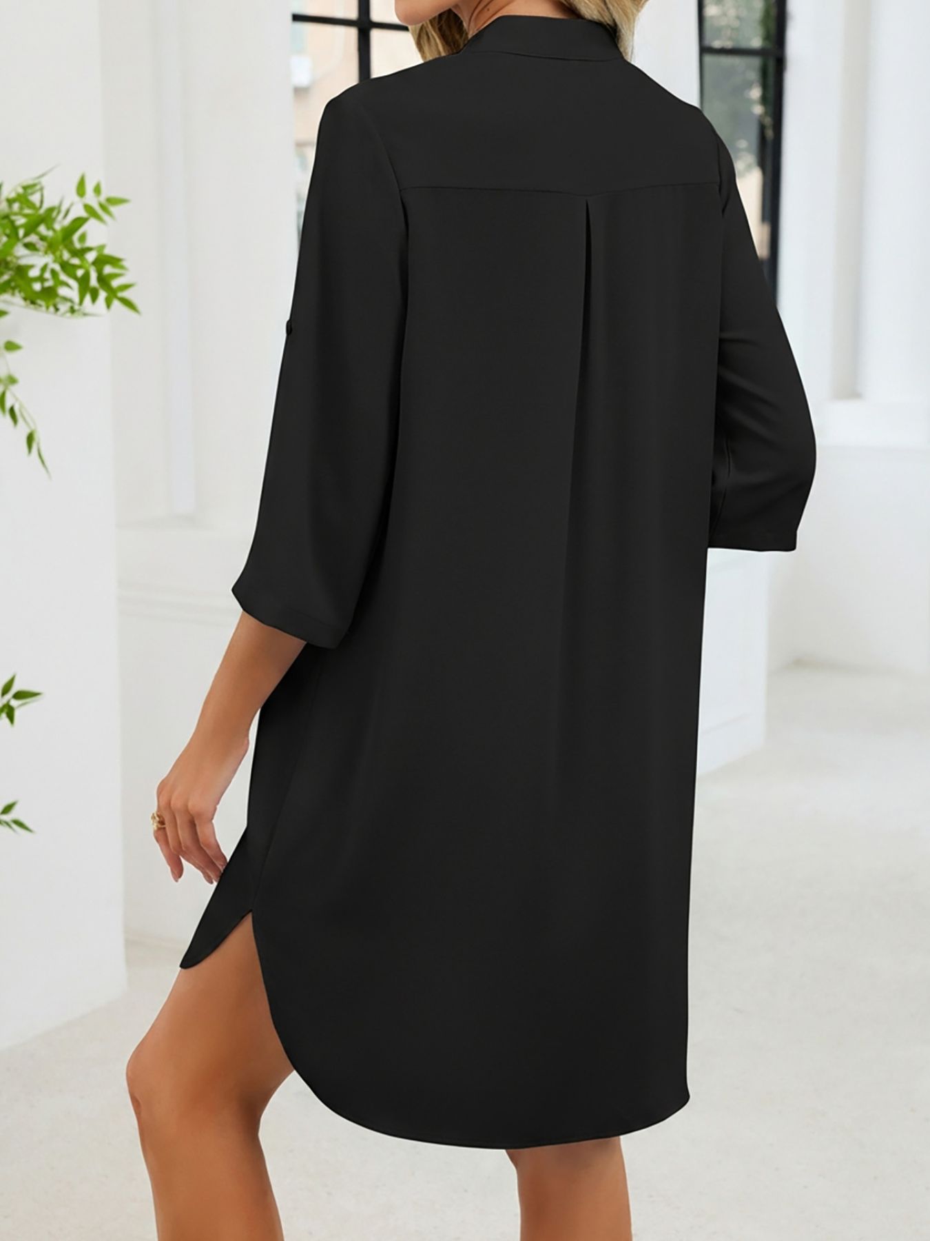 Black button-down shirt dress with band collar, three-quarter sleeves, and side slits.