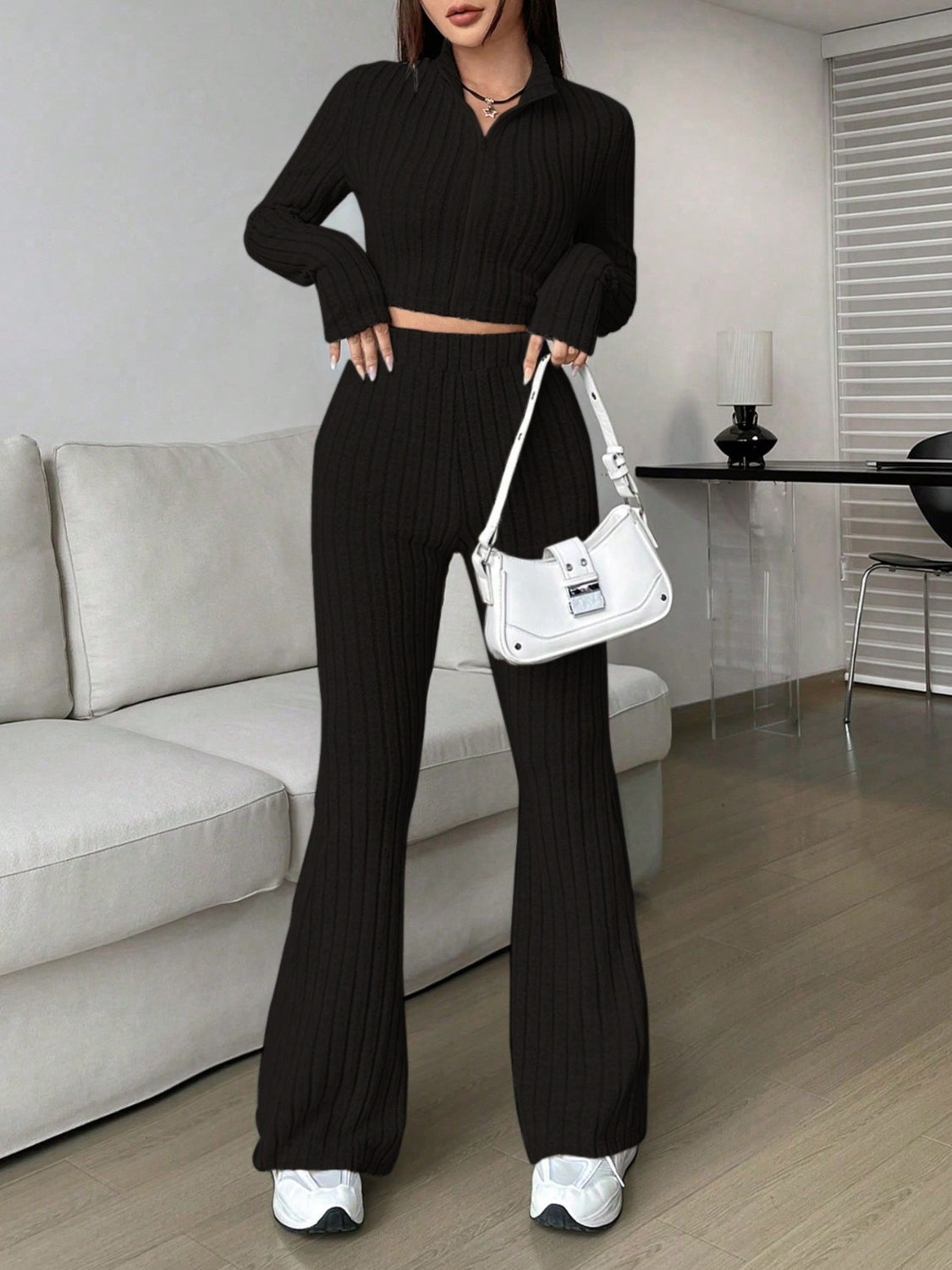 Black ribbed knit flare co-ord set with zip-neck crop top and high-waisted flared pants.