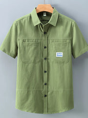 Men's moss green cotton short-sleeve utility shirt with two chest pockets and button front.