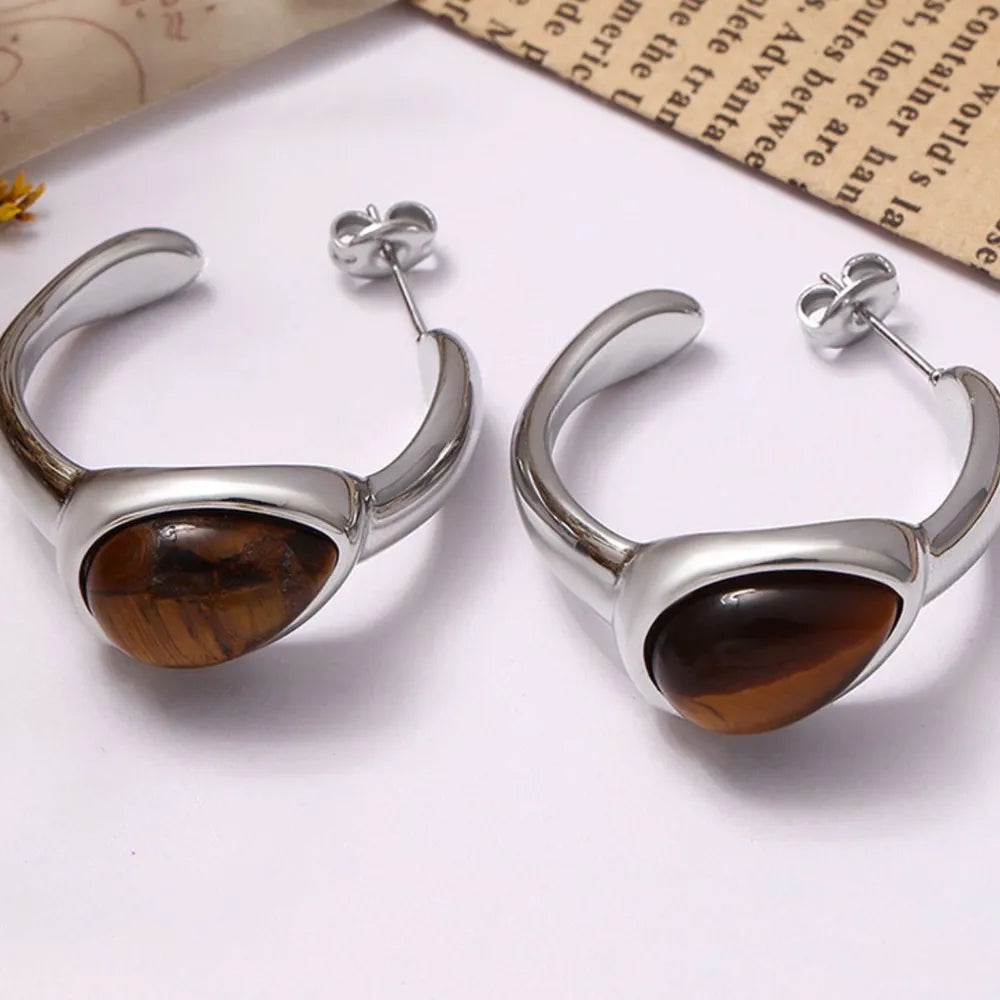 Silver sculptural hoop earrings with tiger's eye stone detail