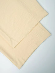 Pastel yellow relaxed wide-leg maternity pants with textured fabric detail.