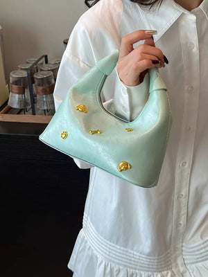 Pastel yellow hobo bag with gold accents and a textured finish.