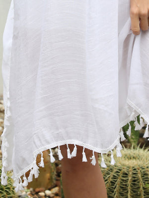 White crochet back tassel trim cover-up with textured fabric and tassel hem.