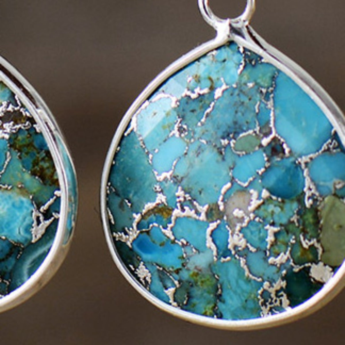 Turquoise matrix teardrop earrings with silver inlay detail.