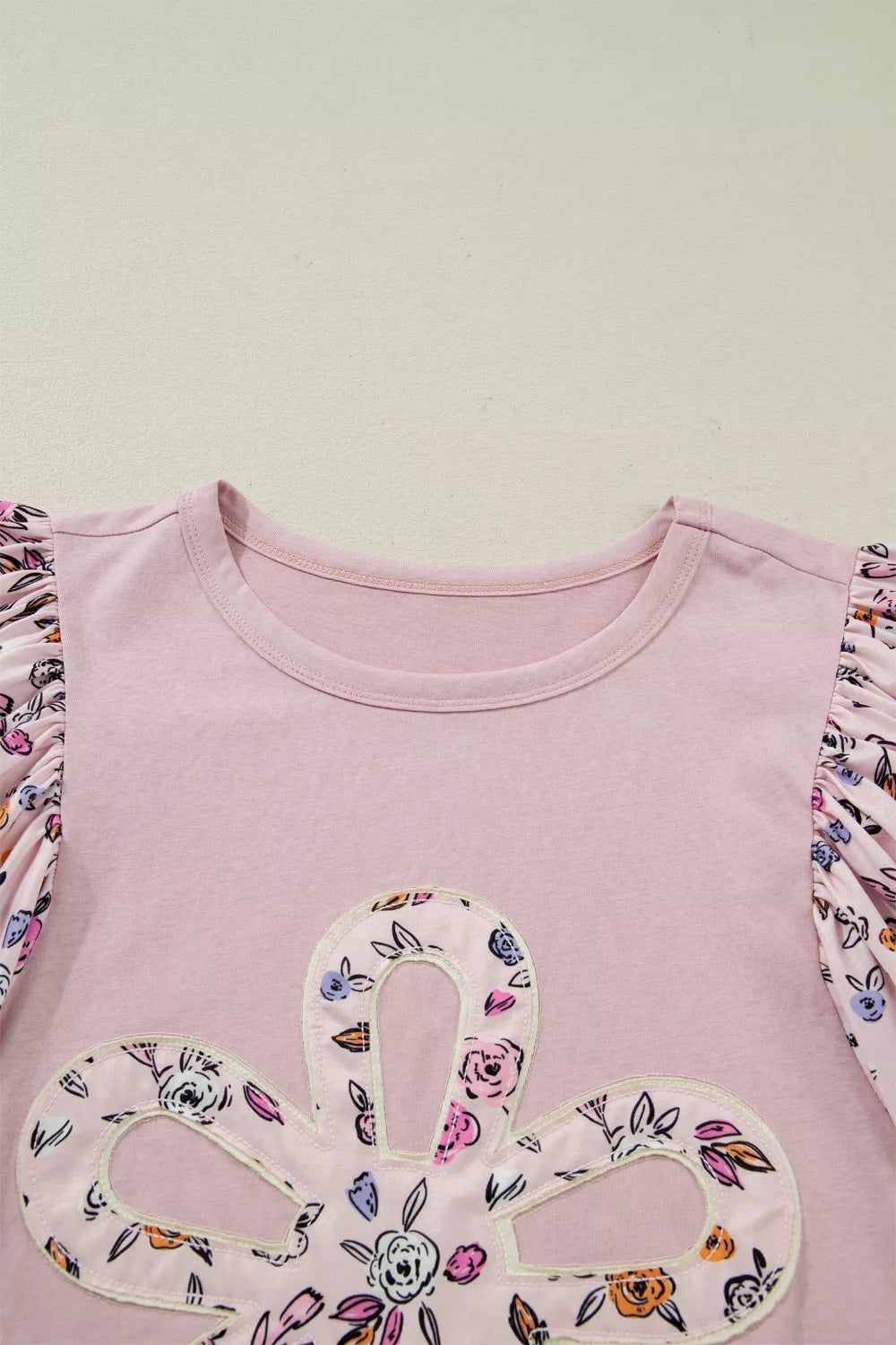Pink cotton crew neck maternity shirt with floral patchwork sleeves and applique detail.