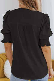 Black puff sleeve blouse with smocking detail on cuffs and gathered back yoke.