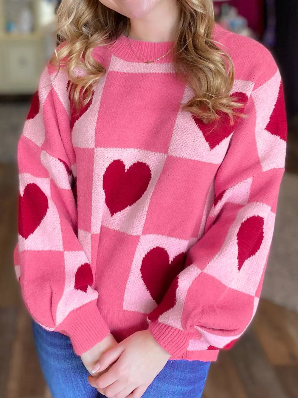Pink and red checkered heart knit sweater with crew neck and balloon sleeves.