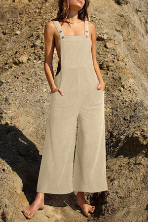Ivory corduroy overalls with wide legs and buttoned straps, featuring front pockets.