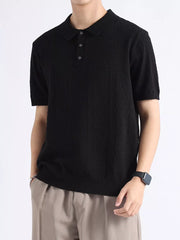 Black cotton blend short-sleeve polo with button detail and classic collar.