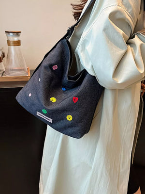 Dark blue denim crossbody bag with embroidered colorful buttons and adjustable strap