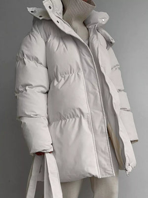 Ivory white puffer trench coat with hood and belt, featuring a zip and button closure.