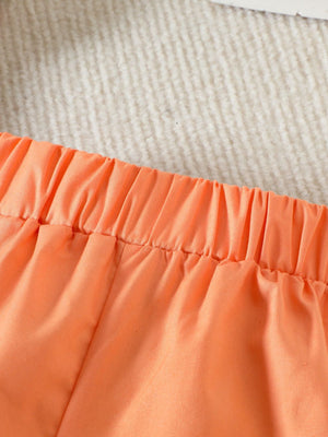 Orange toddler shorts with elastic waistband and gathered detail.