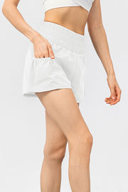 White active shorts with gathered elastic waistband and side pockets.