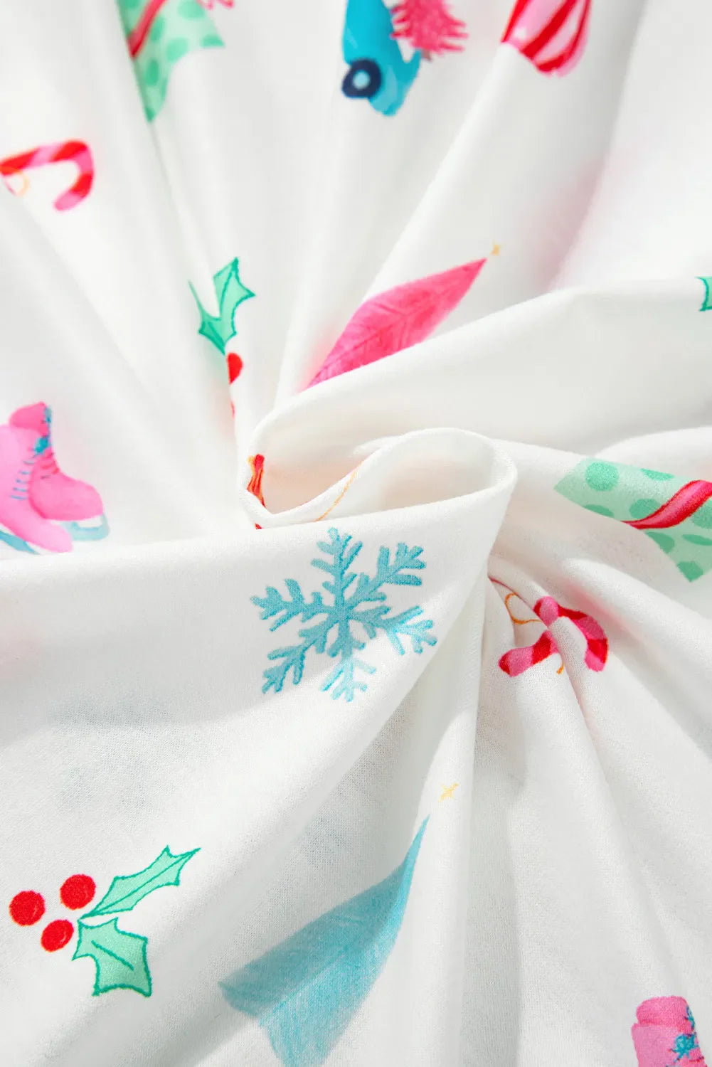 White pajama set with festive Christmas print including snowflakes, skates, and holly.