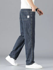 Men's dark wash straight leg jeans in cotton, shown from the side with a white t-shirt and sneakers.