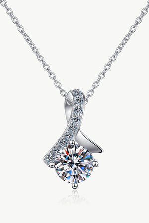 Silver pendant necklace with a large solitaire diamond and a ribbon of smaller diamonds.