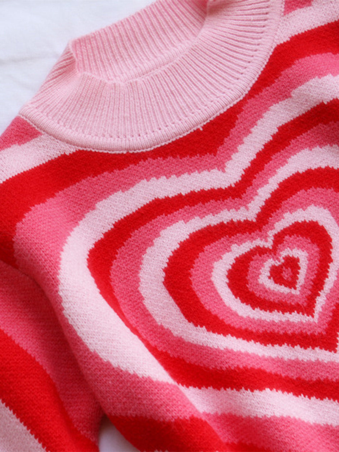 Pink and red striped mock neck knit sweater with heart pattern detail