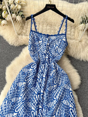 Blue and white lace-embroidered cami dress with tiered skirt and cutout details.