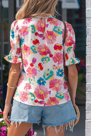 Vibrant floral print cotton blend shirt with ruched short sleeves and a ruffled neckline.