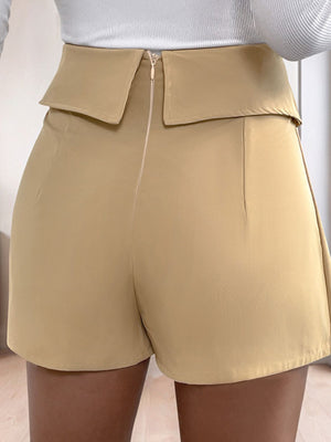 Tan collar-waist pleated skort shorts with a zip closure and a folded waistband detail.