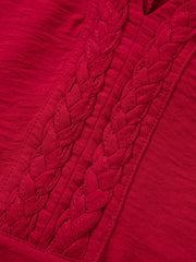 Deep red braided V-neck blouse with textured fabric and braided neckline detail.