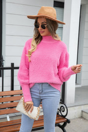 Fluffy pink mock neck sweater with balloon sleeves, styled with jeans and a handbag.
