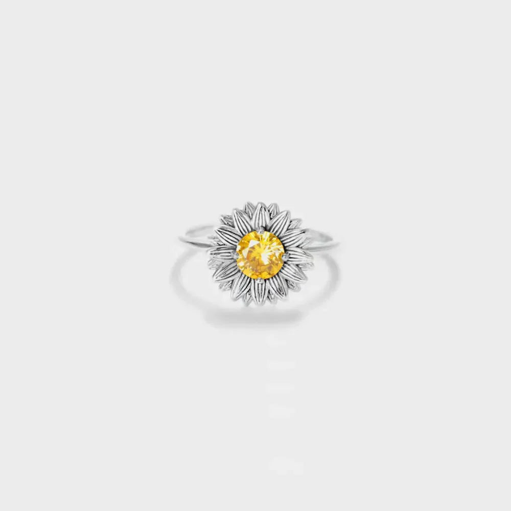 Silver sunflower ring with yellow gemstone center and detailed petals.