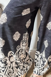 Black palazzo trousers with a white damask print and wide legs.