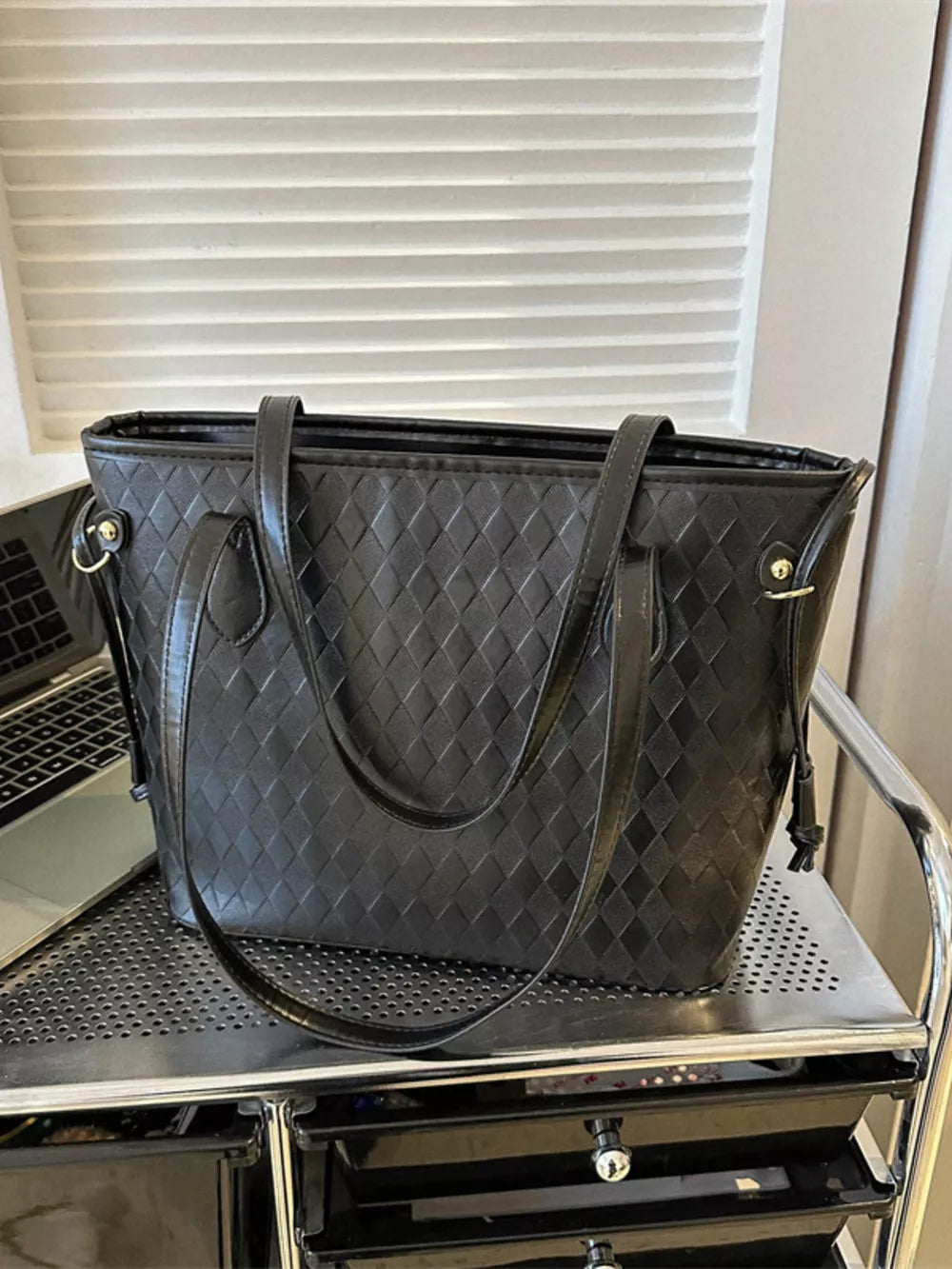 Black textured diamond woven tote bag with charm detail