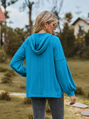 Sky blue textured knit hoodie with balloon sleeves and cable detail.