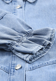 Light blue denim shirtdress with ruffled cuff detail and button closure.