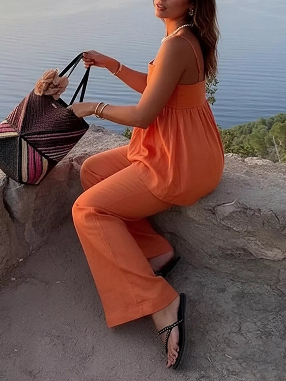 Orange square neck cami and wide-leg pants set with a woven tote bag.