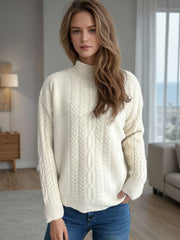 Cream cable knit mock neck pullover sweater with textured details.