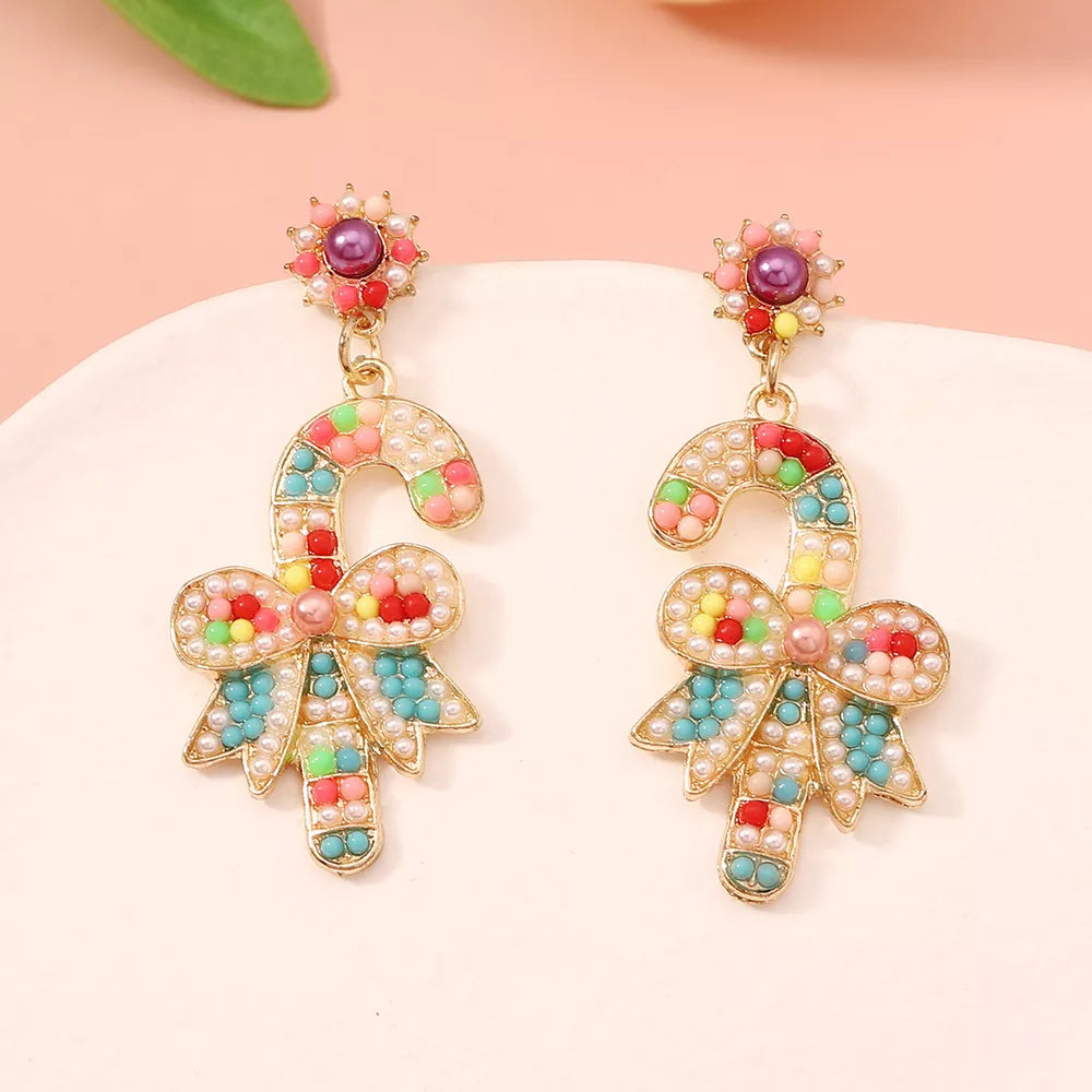 Festive candy cane bow earrings with colorful beads and pearl accents.
