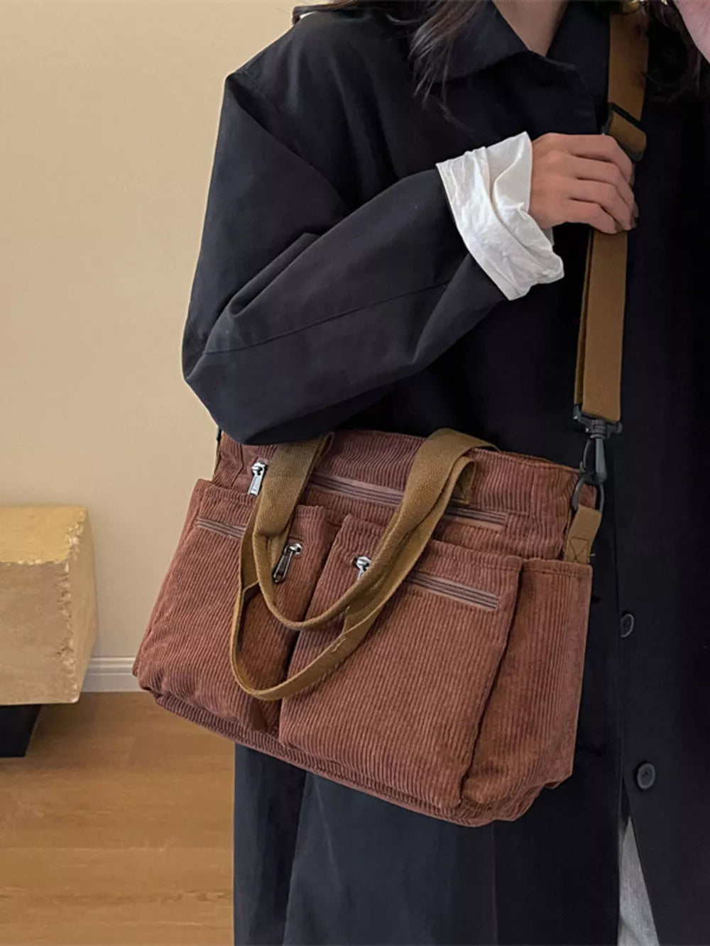 Brown corduroy crossbody bag with multiple pockets and adjustable strap.