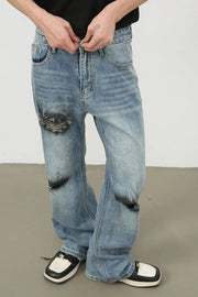 Distressed flare leg jeans in medium wash denim with ripped knee details.