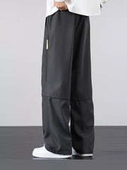 Men's gray cargo pants with a loose fit and zippered pocket detail.