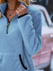 Blue fuzzy fleece quarter zip pullover with black trim and pocket detail.