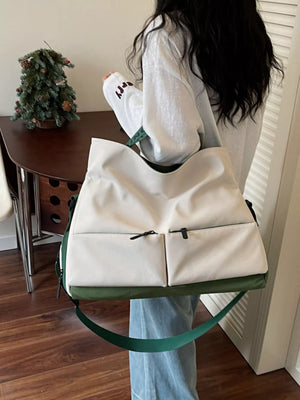 Ivory Oxford cloth travel bag with two front zip pockets and green accents.