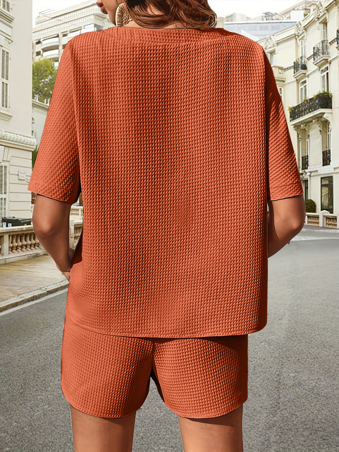 Waffle knit drawstring co-ord set in burnt orange with short sleeves and shorts.
